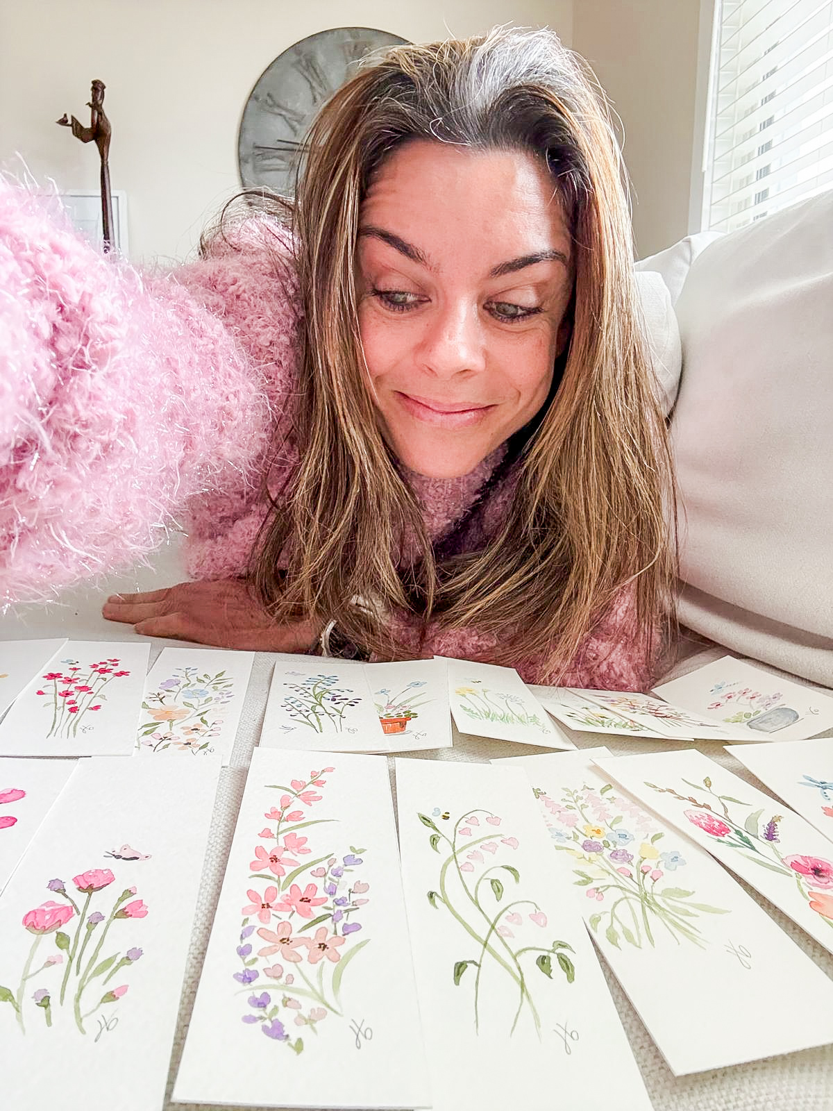 Watercolor wildflower bookmarks laid out on a couch