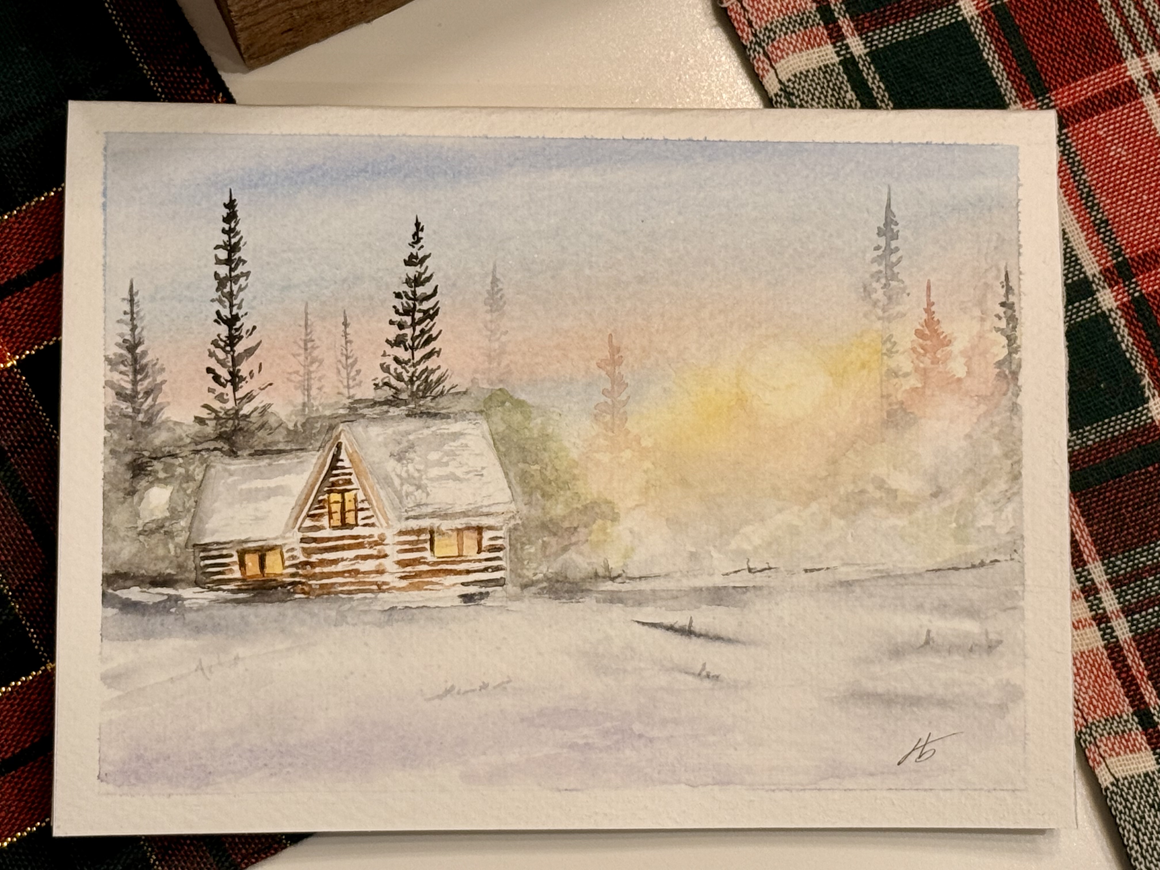 Watercolor of a cabin at dusk with light glowing from its windows under tall evergreens